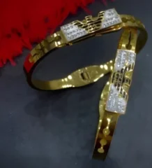 Gold color eagle bangle with a designer motif and textured silver color details for artificial jewellery shopping in Lahore.