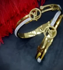 Gold color fashion bangle with dual-tone silver color accents and a designer cutout motif for artificial jewellery shopping in Lahore.