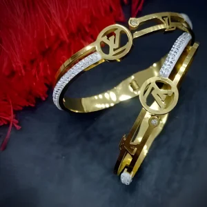 Gold color fashion bangle with dual-tone silver color accents and a designer cutout motif for artificial jewellery shopping in Lahore.